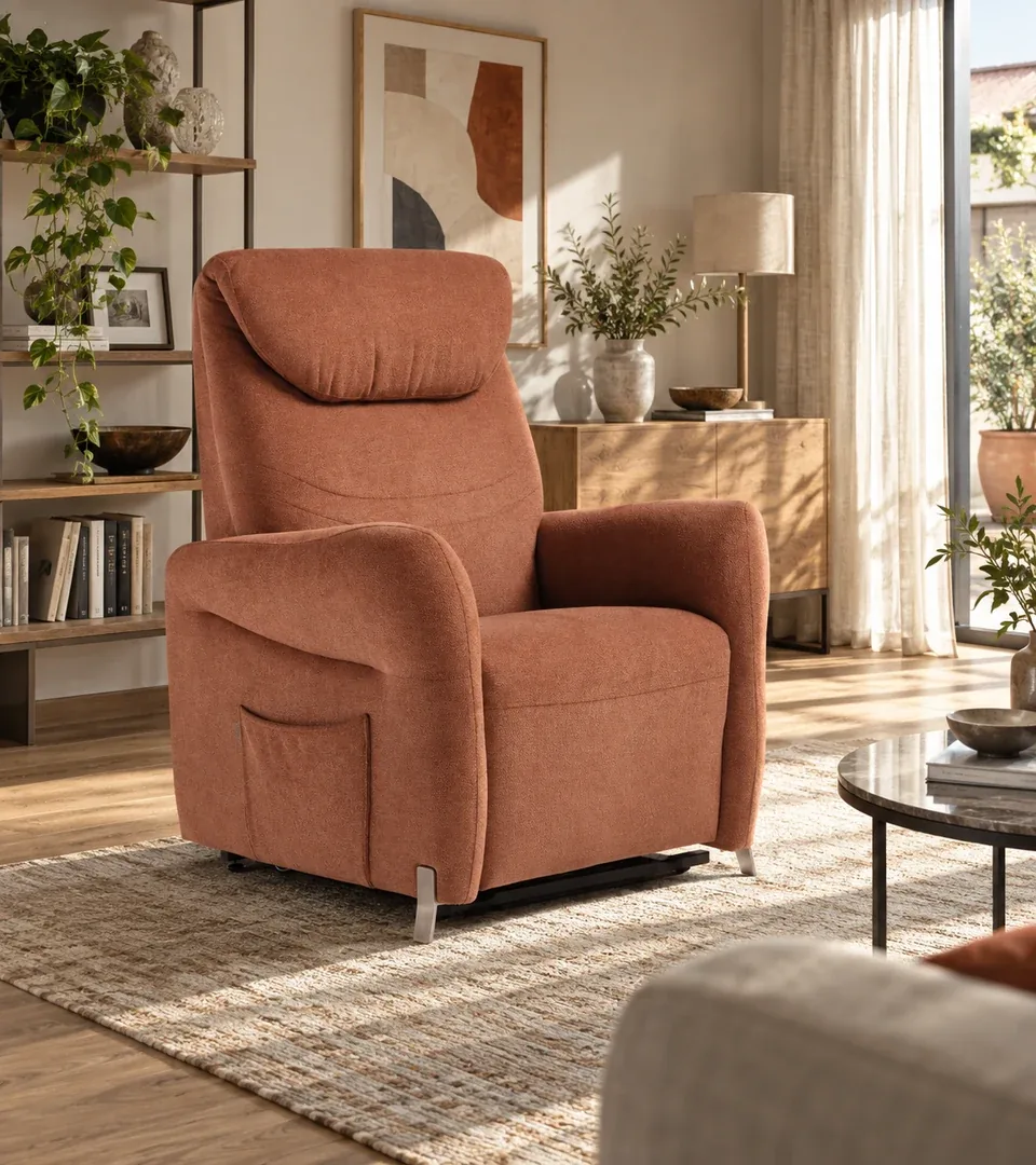 Poltrona alzapersona Raya color terracotta in un soggiorno con libreria